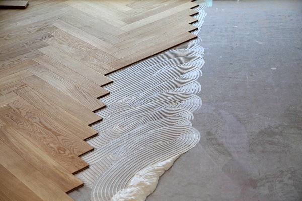 On‑site measure inspecting timber flooring planks