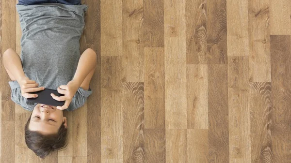 Child lying on warm oak laminate flooring in a Hills District family home